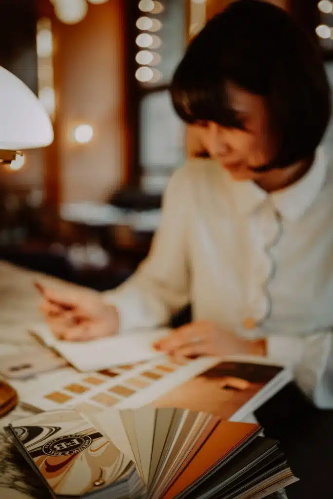 Architecte d’intérieur en Alsace consultant un carnet de matières pour un projet d’aménagement intérieur