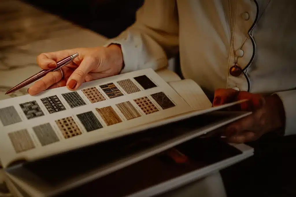 Architecte d’intérieur en Alsace étudiant des échantillons et nuanciers pour un projet sur mesure