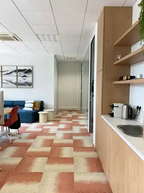 Coin cuisine et espace bureau aménagés par Melvi Intérieur avec mobilier bois clair et zone détente intégrée
