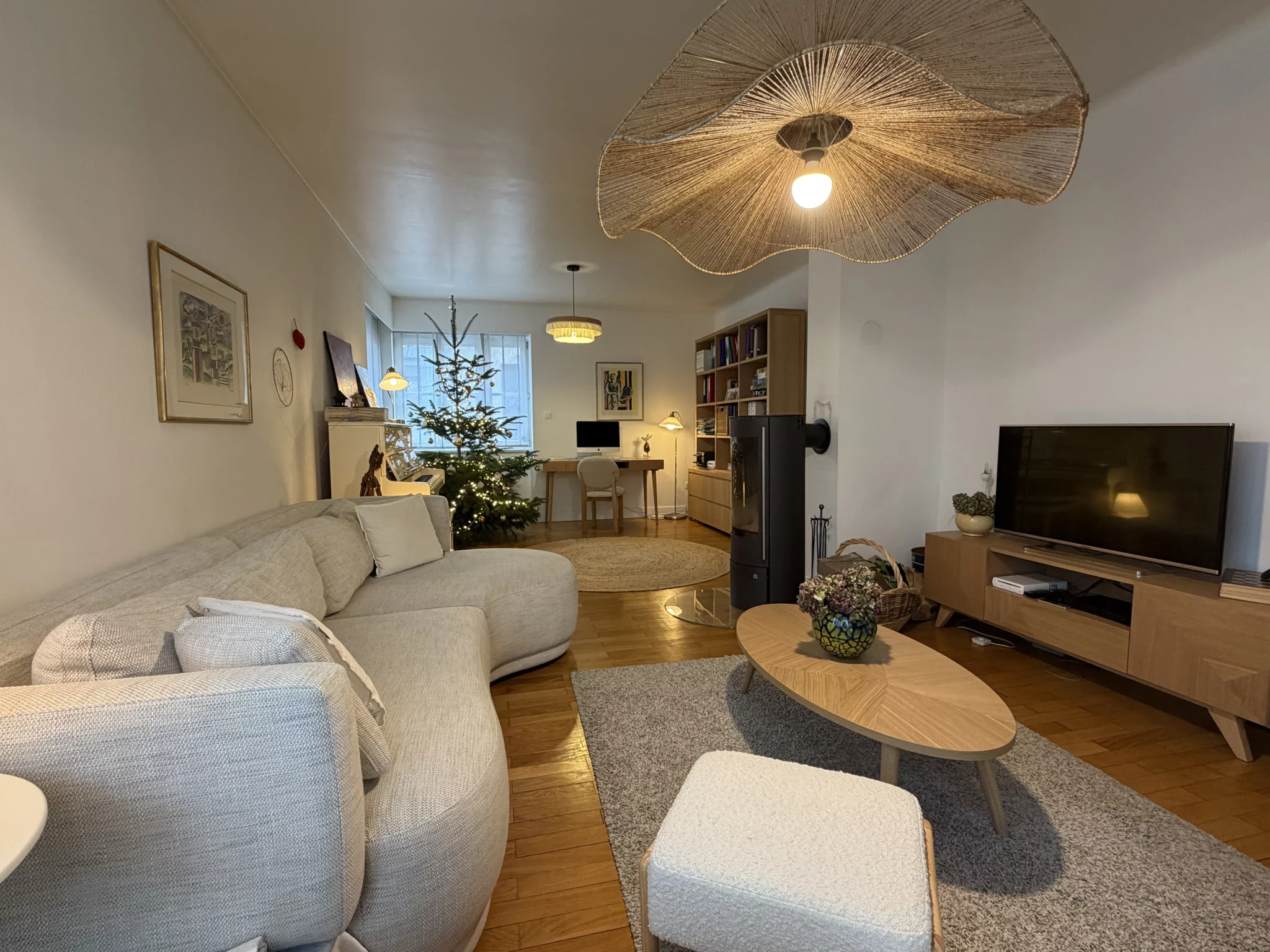 Salon rénové avec coin bureau, canapé courbe et décoration lumineuse conçu par Melvi Intérieur